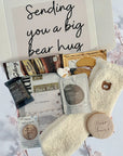 Sending Bear Retirement Gift Box featuring a soft teddy socks, sweet treats, a relaxing foot mask, and a retirement card, beautifully arranged to celebrate this special milestone.