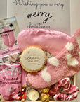 Gift set with pink lip mask, eye mask, popcorn, and cookie with 'Wishing you a very merry Christmas' text.