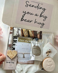 Sending Bear Hugs gift box with a soft teddy socks, comforting treats, and a thoughtful card, all arranged in a cosy package to show love and care.