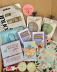 A comforting ‘Thinking of You’ package filled with thoughtful treats and self-care items, such as tea, pamper items, a bracelet, and a handwritten note, neatly arranged in a gift box