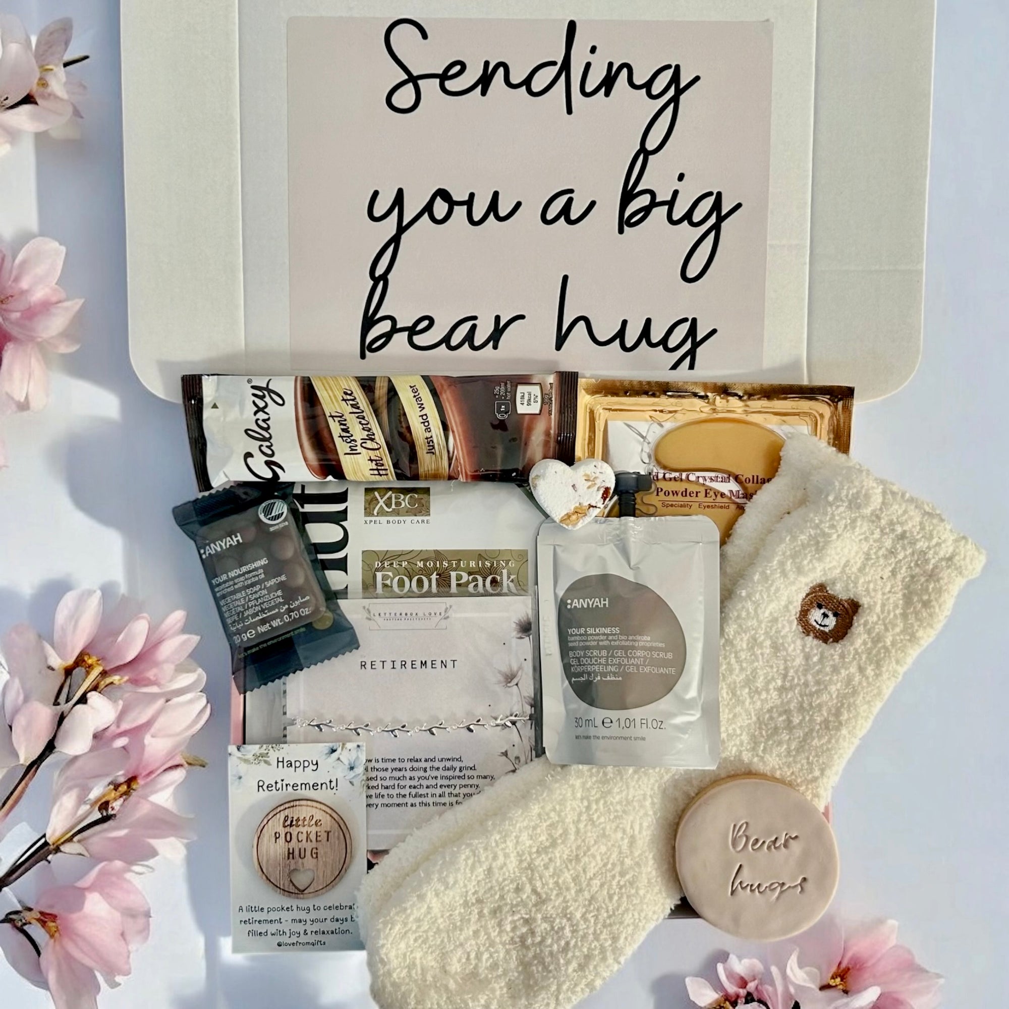 Sending Bear Retirement Gift Box featuring a soft teddy socks, sweet treats, a relaxing foot mask, and a retirement card, beautifully arranged to celebrate this special milestone.