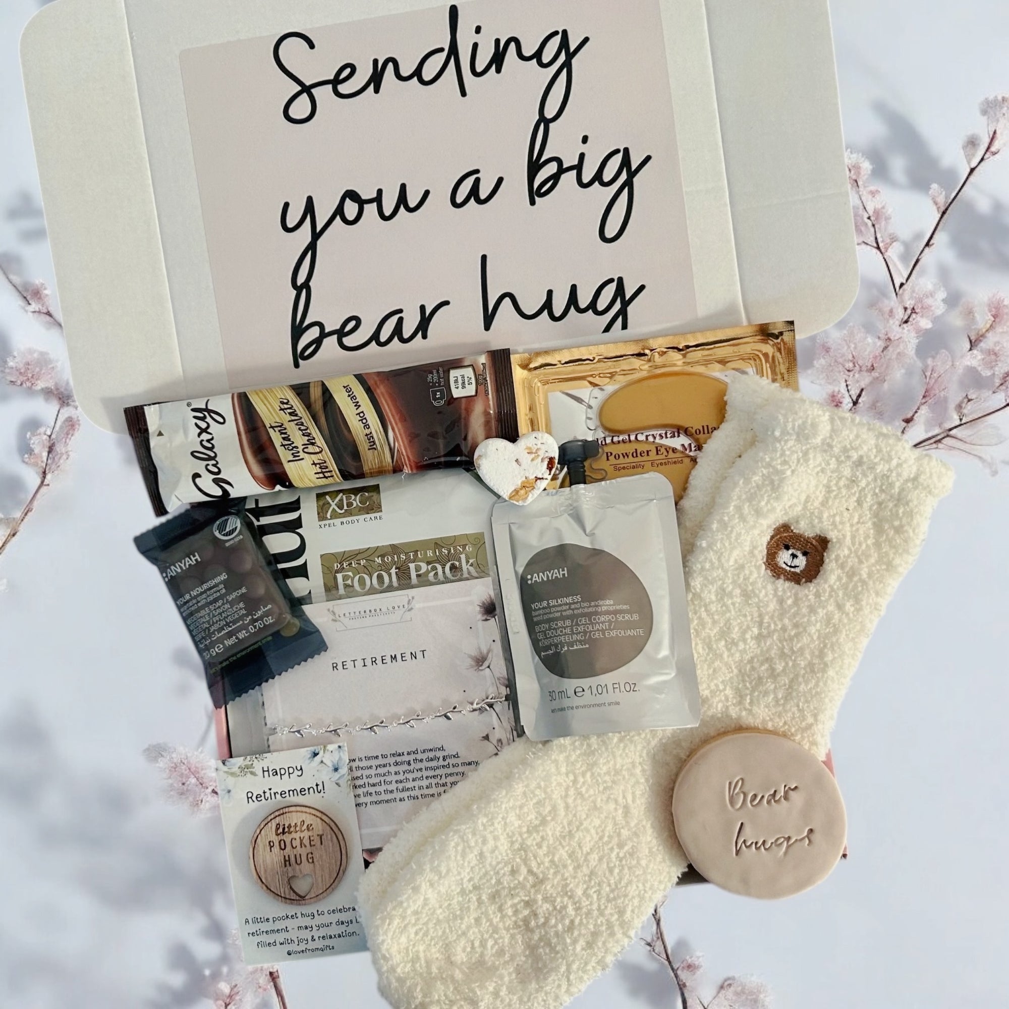 Sending Bear Retirement Gift Box featuring a soft teddy socks, sweet treats, a relaxing foot mask, and a retirement card, beautifully arranged to celebrate this special milestone.