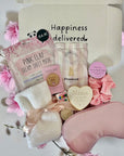 Mum-to-Be gift set including a relaxing face mask, delicious cookie, calming bath salts, and assorted treats, beautifully arranged in a cosy gift box.