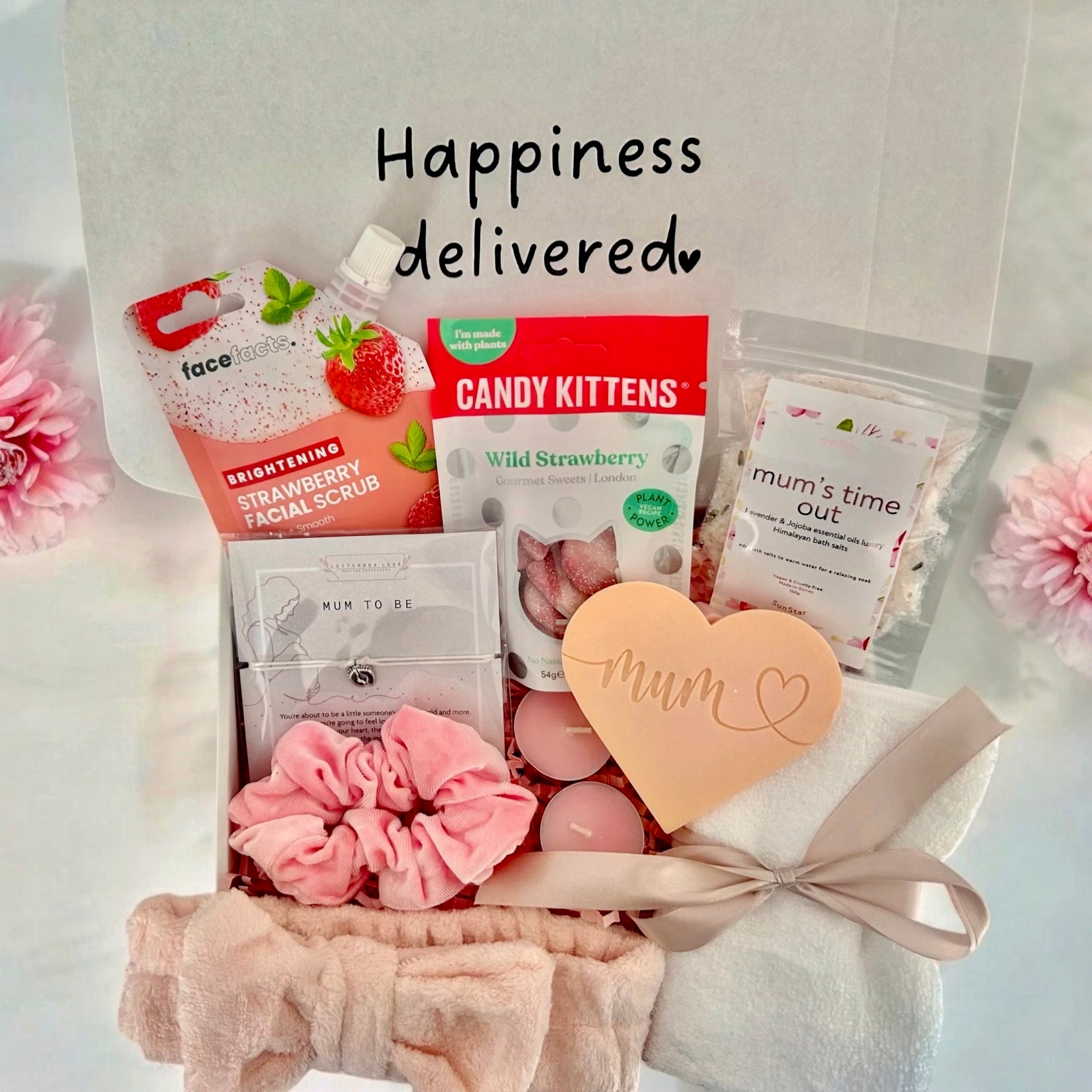 A thoughtful mum-to-be care package with self-care essentials, including cosy socks, Relaxing face mask, a soothing wax melt, Mums time out bath salt, snacks, and a handwritten note, all beautifully arranged in a gift box.