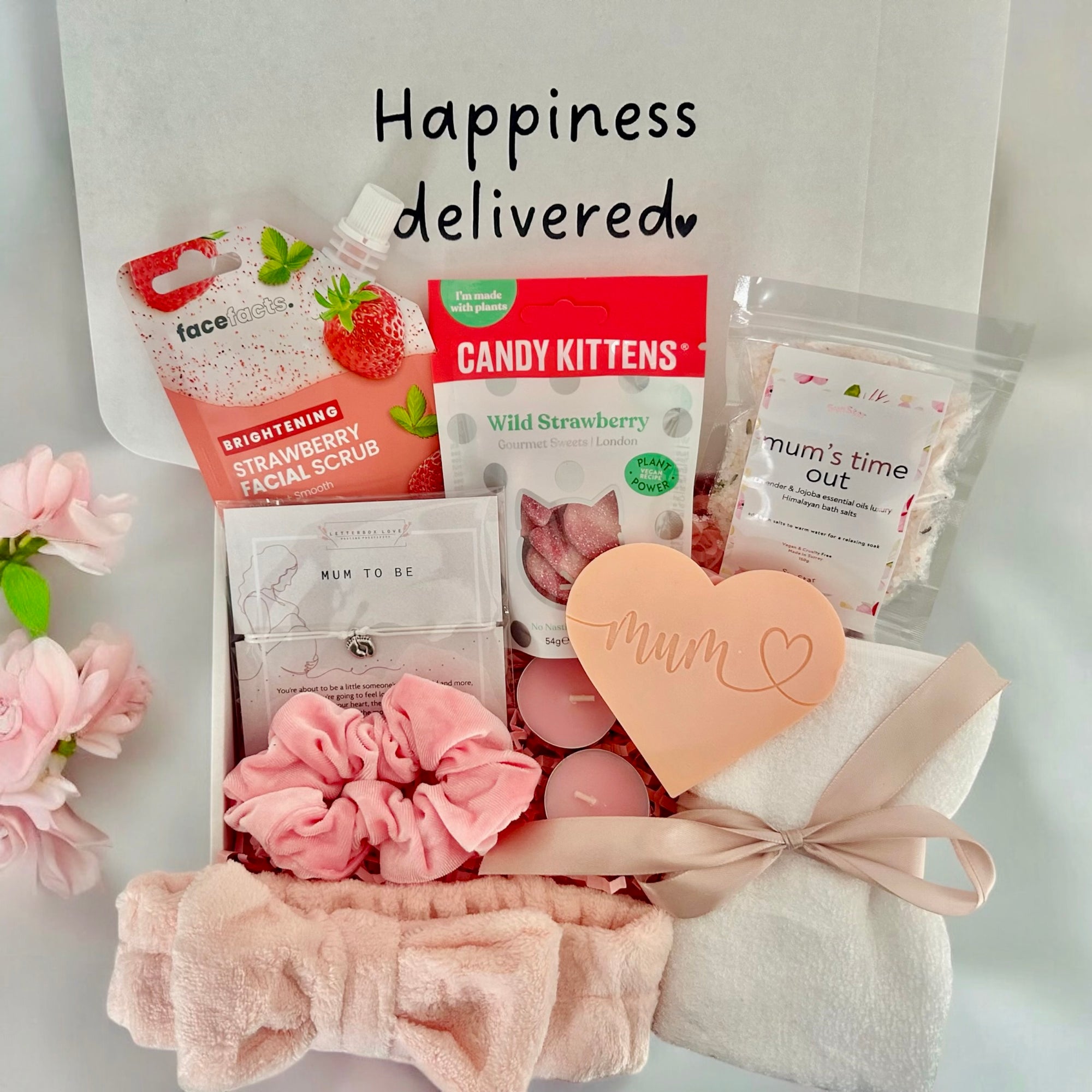 A thoughtful mum-to-be care package with self-care essentials, including cosy socks, Relaxing face mask, a soothing wax melt, Mums time out bath salt, snacks, and a handwritten note, all beautifully arranged in a gift box.
