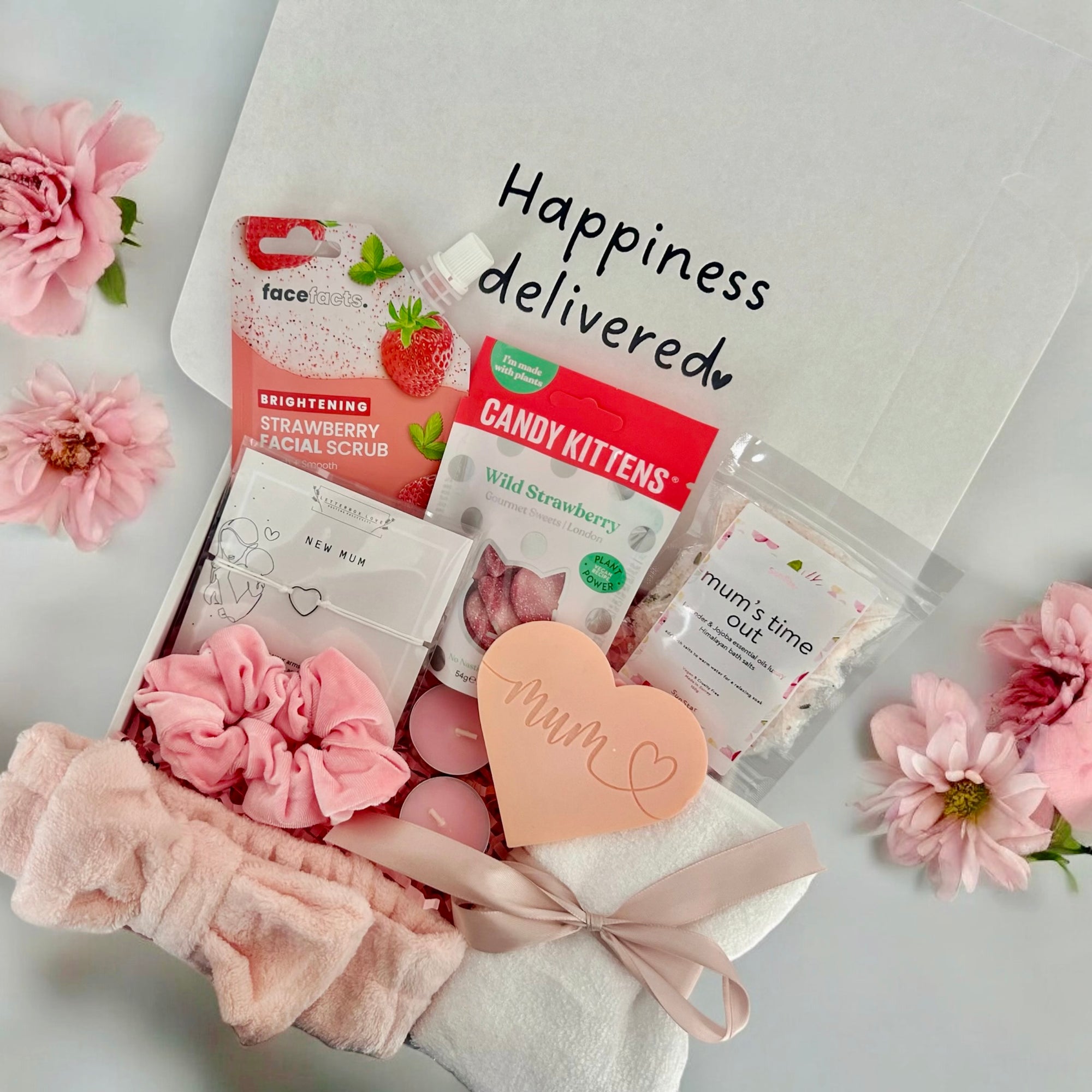 New Mum gift box featuring soothing face mask, indulgent cookie, calming bath salts, and assorted treats, thoughtfully curated to pamper and relax new mothers.