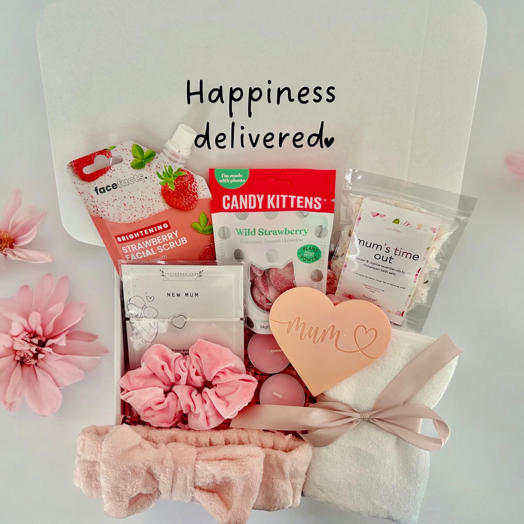 New Mum gift box featuring soothing face mask, indulgent cookie, calming bath salts, and assorted treats, thoughtfully curated to pamper and relax new mothers.
